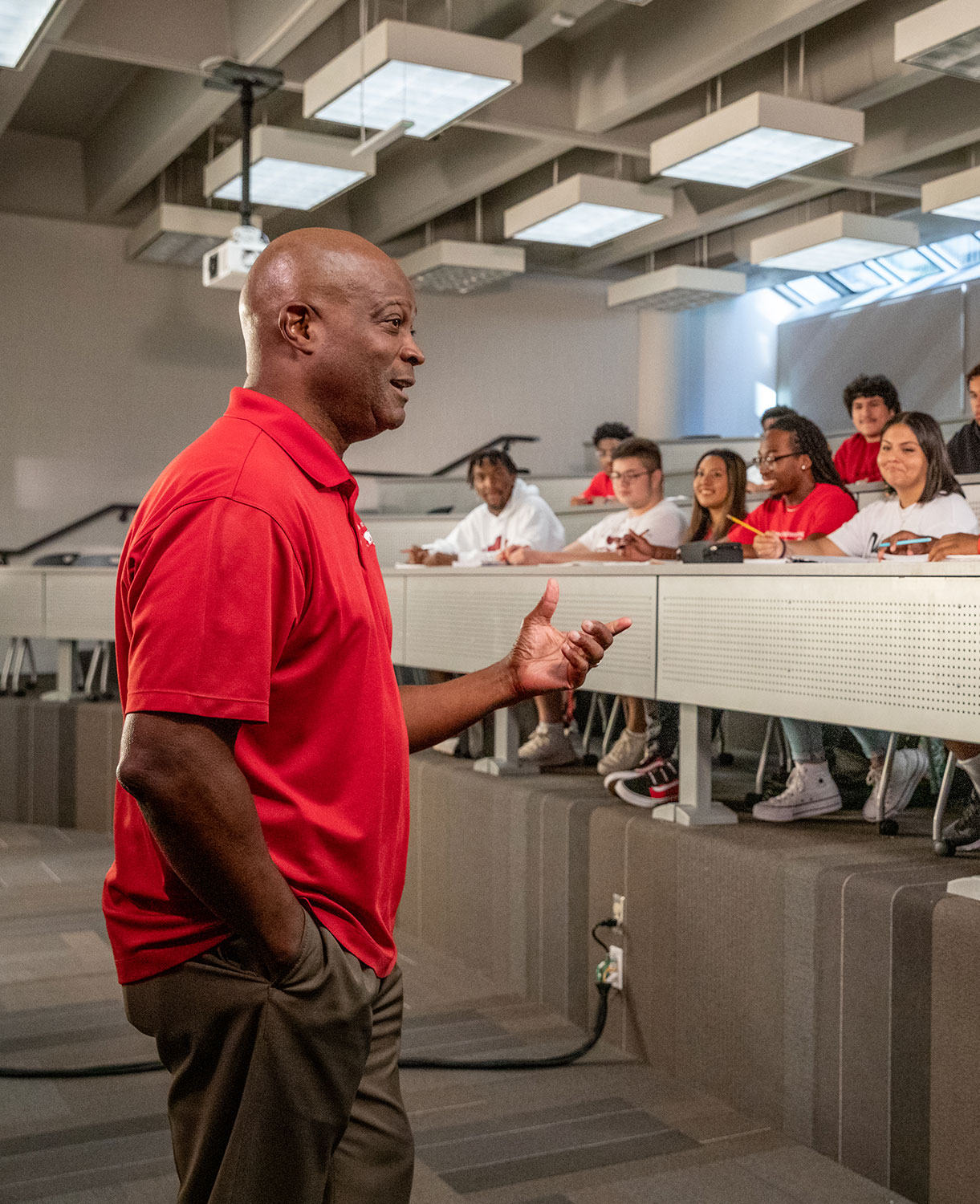 A teacher speaking to a room full of students.
